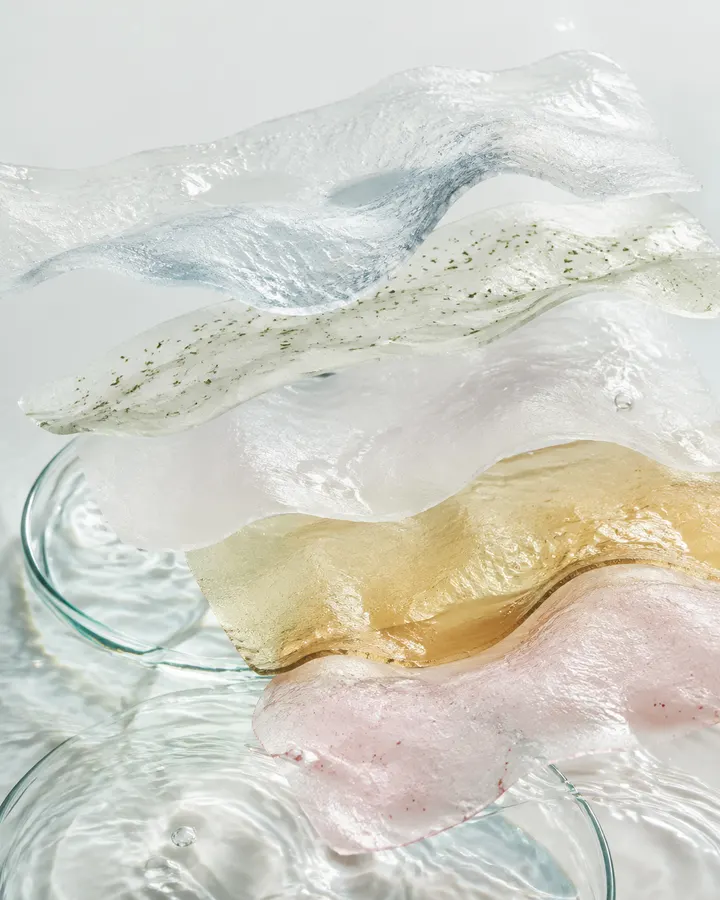 Translucent essence-soaked sheet materials layered above water